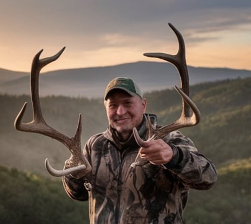 Matthew posing with antler after successful hunt